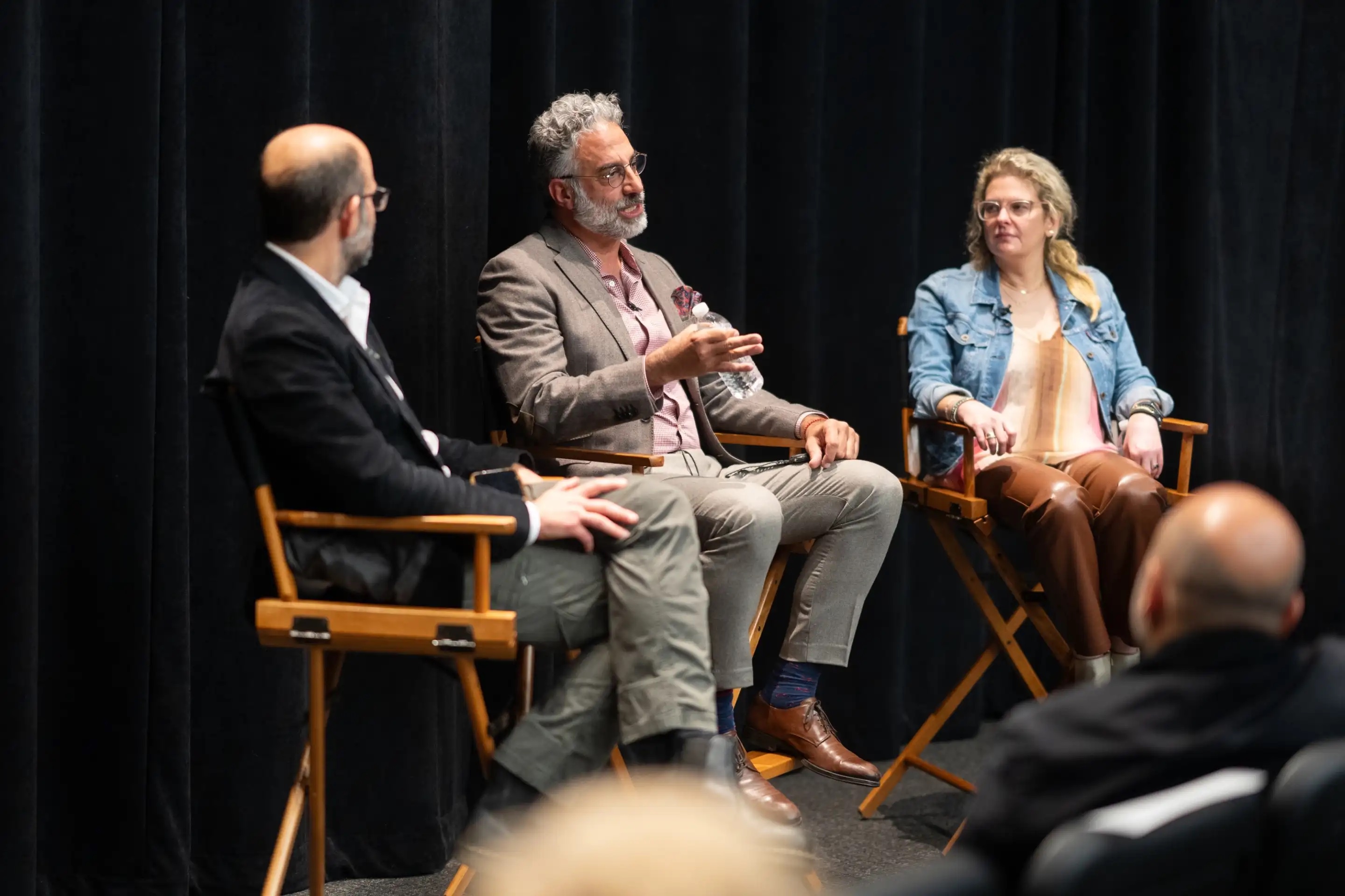 Three seated individuals on a stage